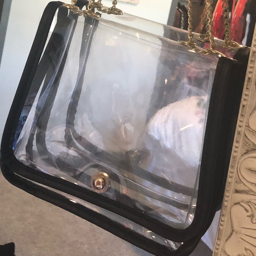 Clear purse with a black leather rim.